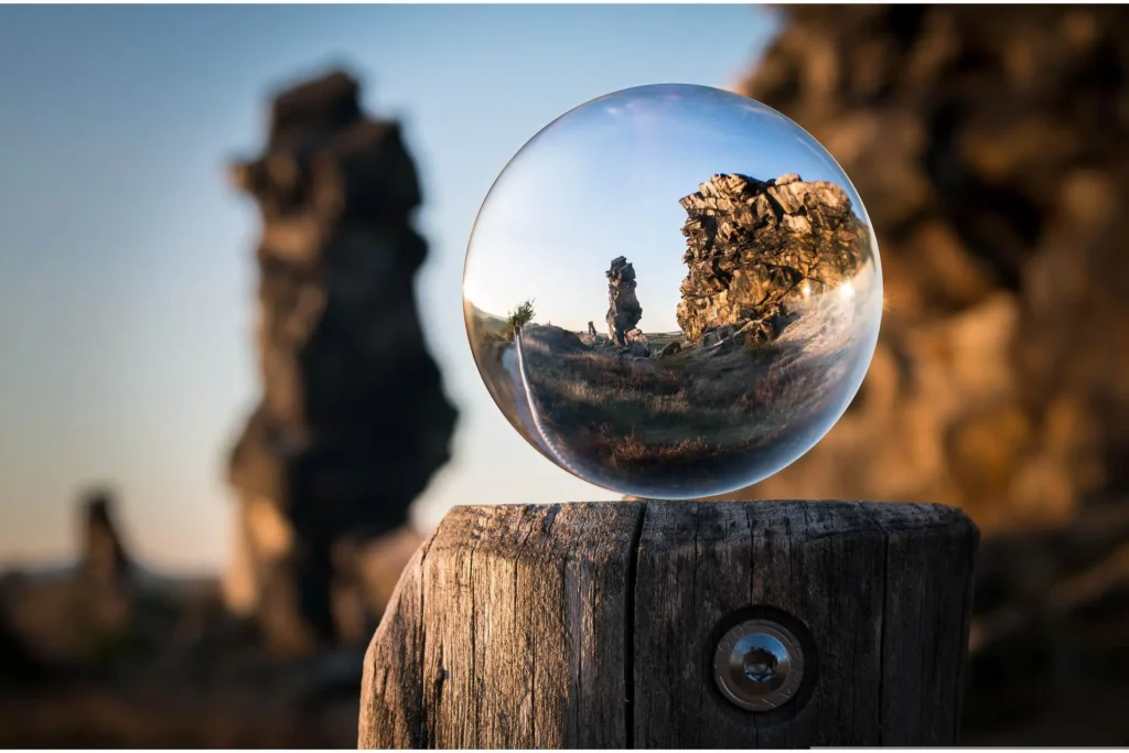 Una esfera de cristal reflejando un paisaje natural.